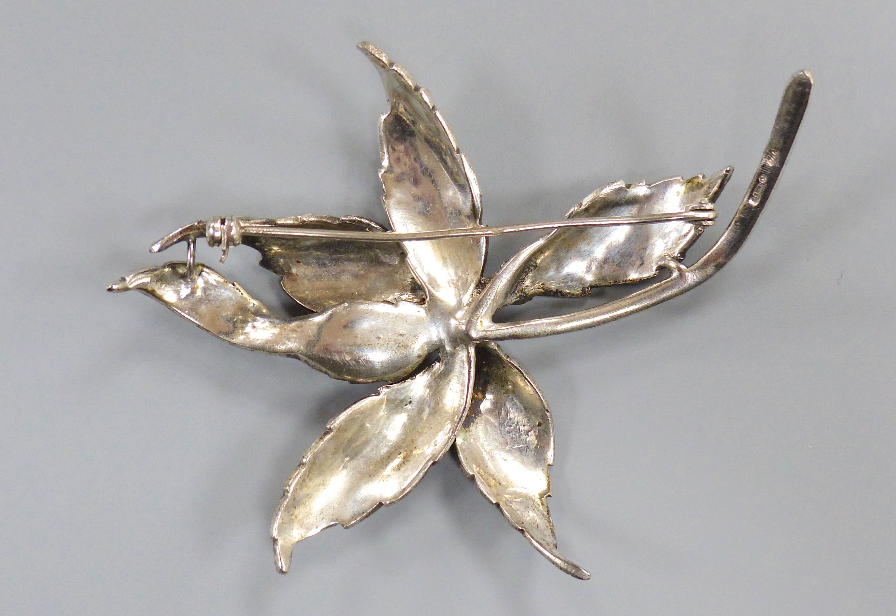 A 1960's silver and marcasite floral spray brooch and a lady's silver and marcasite wrist watch.